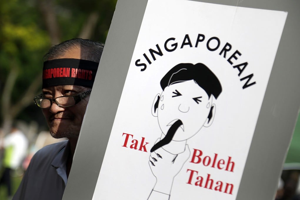 A man carries a poster that translates as "Singaporean can''t take it" to protest against a perceived influx of foreigners to the city state. Photo: AP
