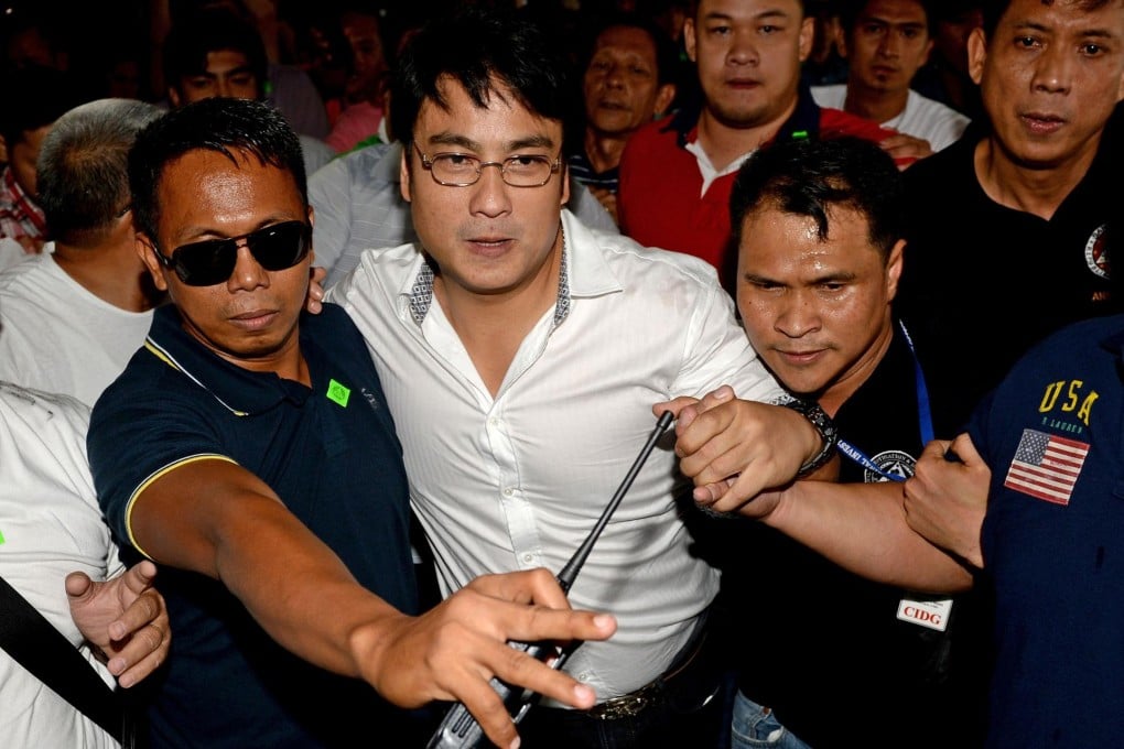 Senator Ramon Revilla is escorted by supporters as he arrives to face charges at the anti-graft court in Manila. Photo: AFP