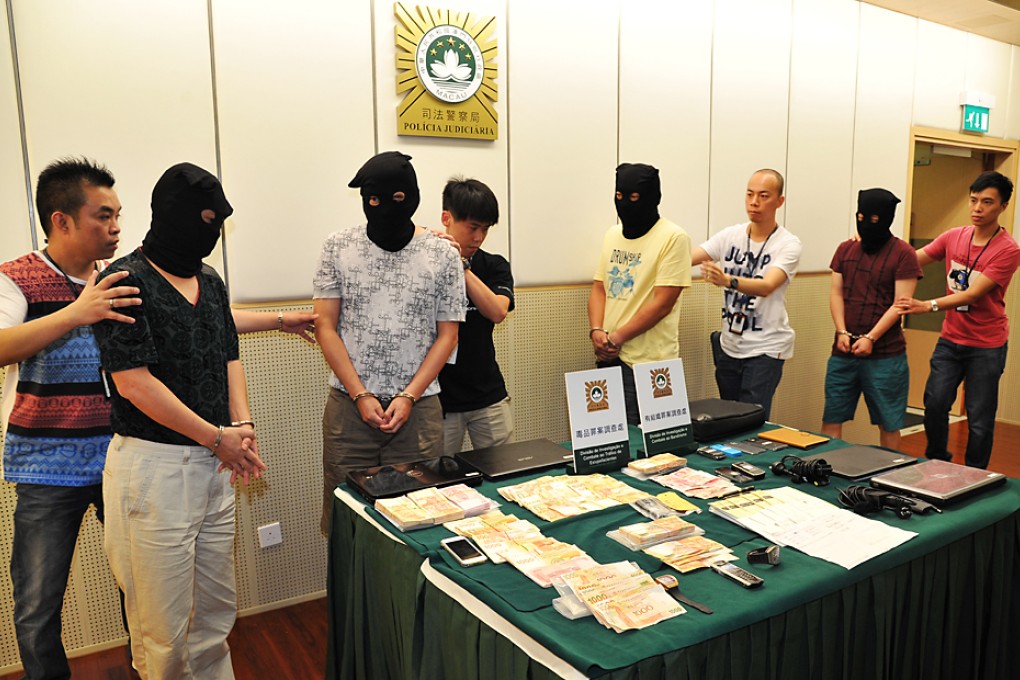 Hooded and in handcuffs, some of the suspects are paraded before the press as Macau police gave details of the raid.  Photo: SCMP Pictures