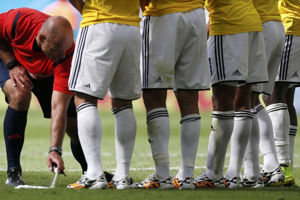 Howard Webb applies the vanishing spray. Photo: Reuters