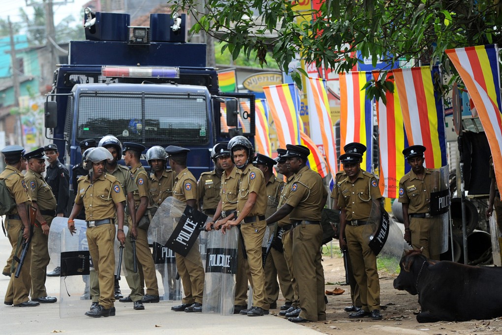 Sri Lankan police stand guard by a roadside in Alutgama following clashes between Muslims and an extremist Buddhist group. The police said they were tightening security in the capital Colombo. Photo: AFP