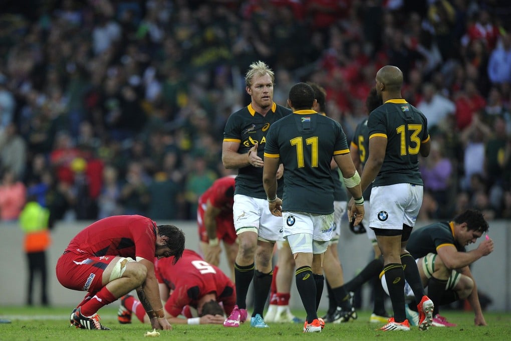 South Africa players have more a sigh of relief rather than celebration, amid dejected Wales players, after the 31-30 win over the visitors in Nelspruit. Photo: AFP