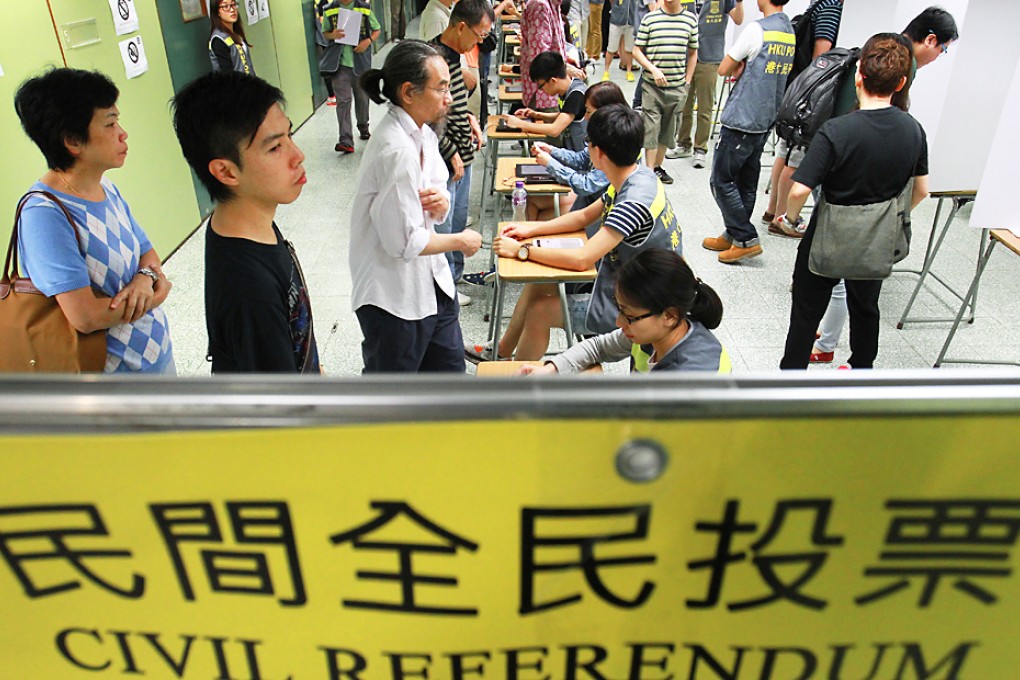 People prepare to cast their vote in Causeway Bay yesterday at one of 15 Occupy Central polling stations. Photo: Dickson Lee