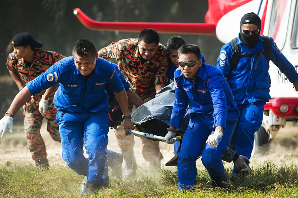 A Malaysian search and rescue team carries a victim's body retrieved from a capsized boat in Kelanang Jetty near Banting after an apparently overloaded boat carrying Indonesian illegal migrants sank in seas off western Malaysia. Photo: AFP