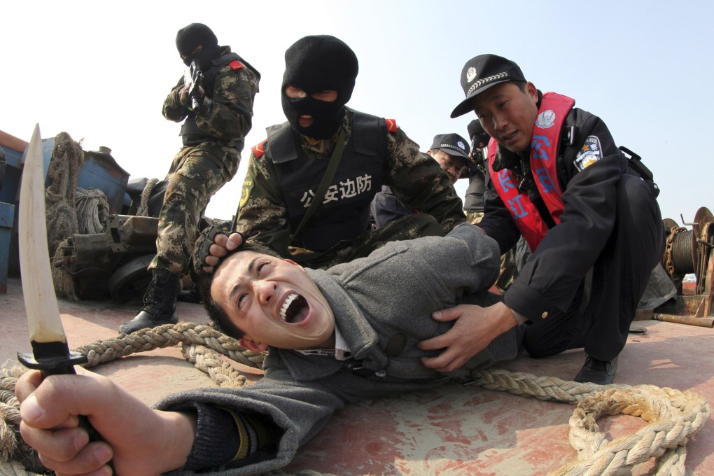 Paramilitary policemen and police officers "arrest" a man acting as an attacker with a knife during an anti-terrorism drill in Rugao, Jiangsu province. Photo: Reuters