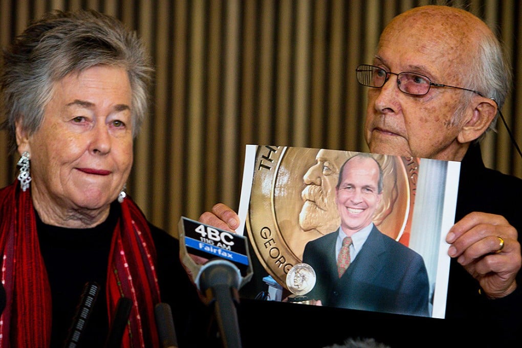 Juris Greste displays a picture of his son, jailed Australian Al-Jazeera journalist Peter Greste, next to his wife Lois during a press conference in Brisbane. Photo: AFP