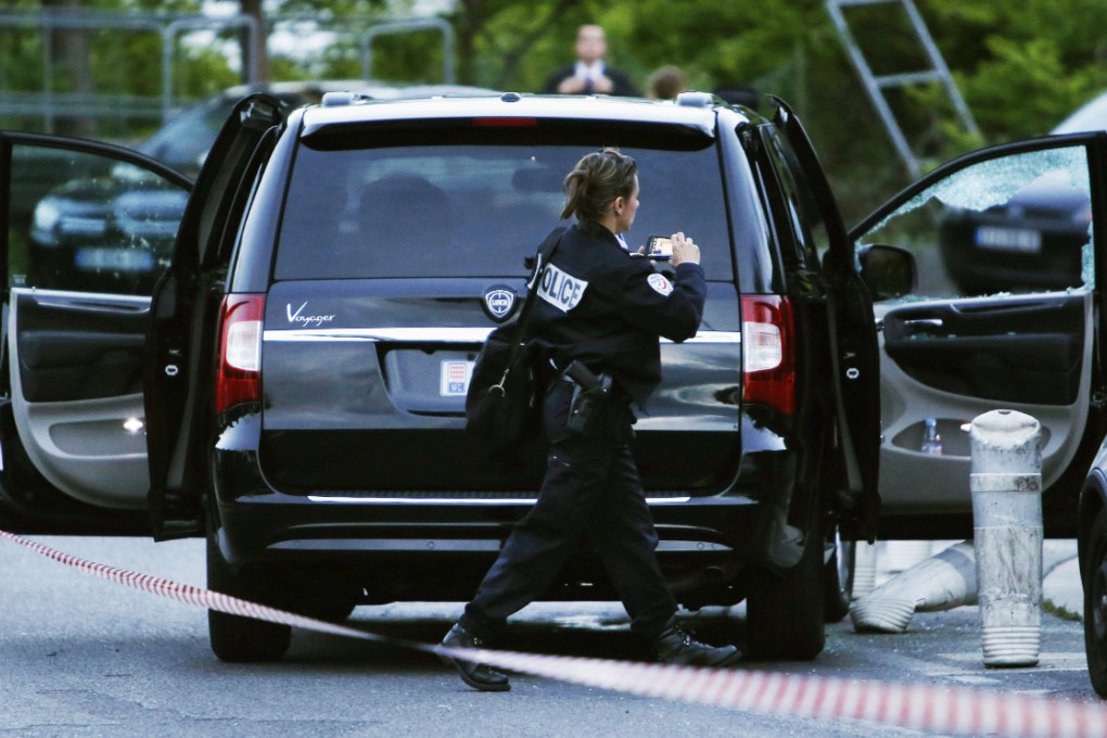 A police officer investigating a car at the site where a shooting killed Helene Pastor and her driver earlier in the evening outside The Archet hospital in Nice, southeastern France. Photo: AFP