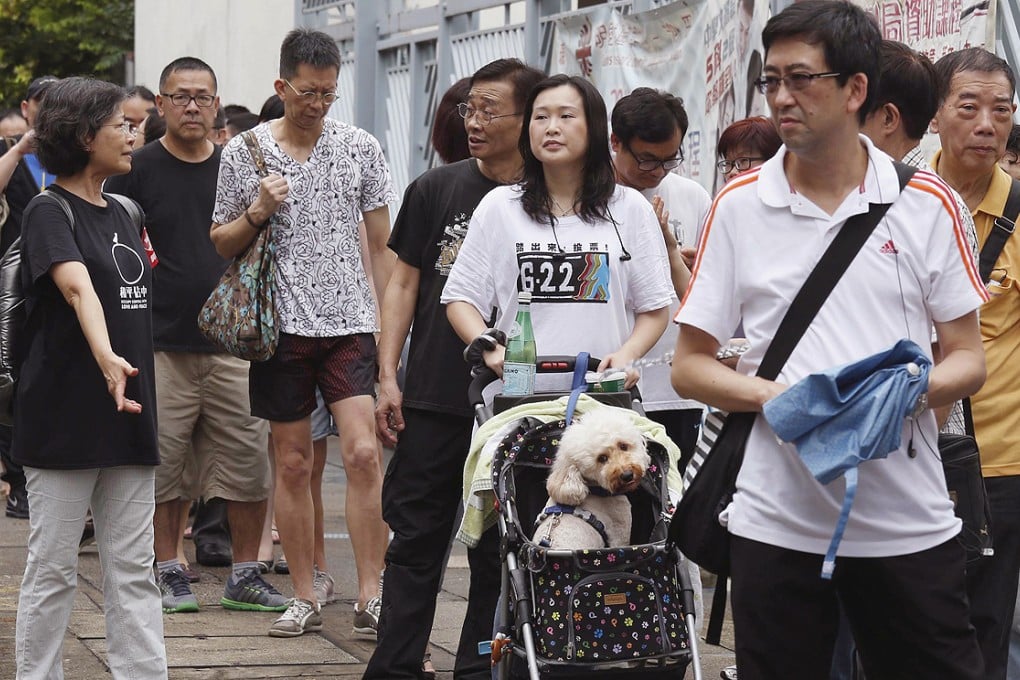 Hongkongers queue up to vote in the unofficial referendum at a polling station on Sunday. The online voting system faced an unprecedented attack. Photo: Bobby Yip/Reuters