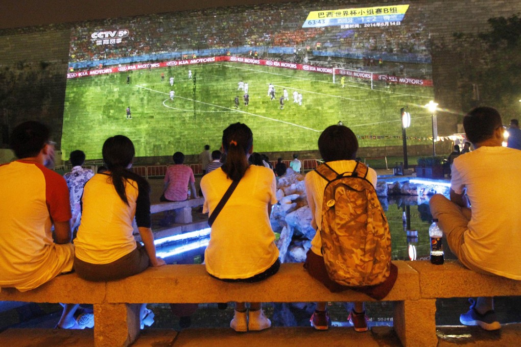 Young people and residents watch a broadcast of a 2014 Brazil World Cup group match which is projected onto an ancient city wall in Nanjing. Photo: Reuters