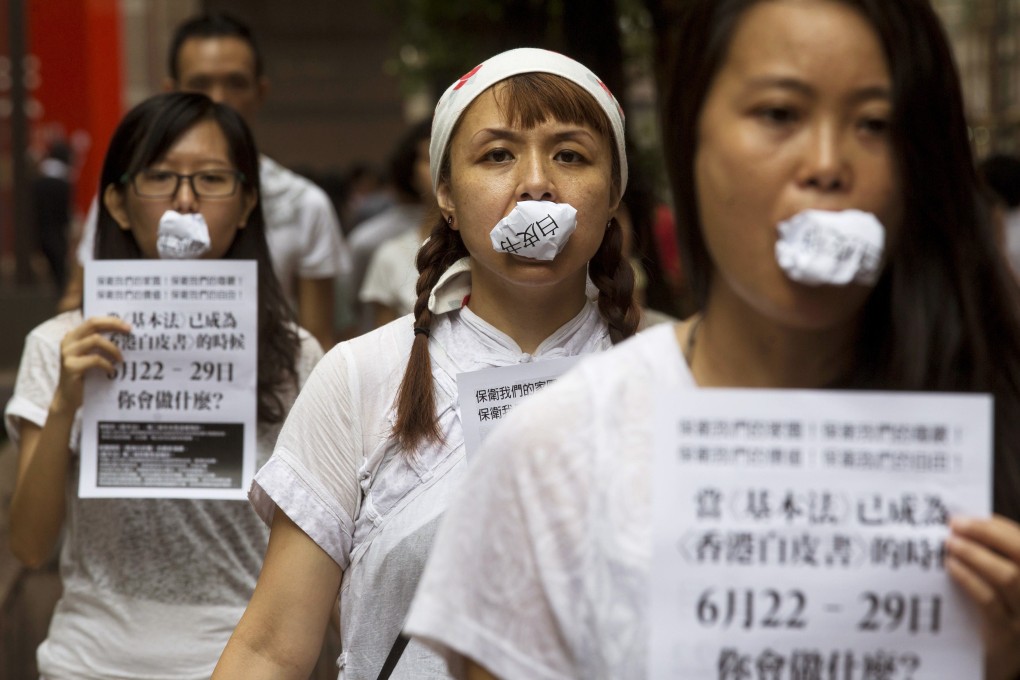 Hong Kong artists gag themselves with photocopies of the white paper in a protest this month. Photo: Reuters