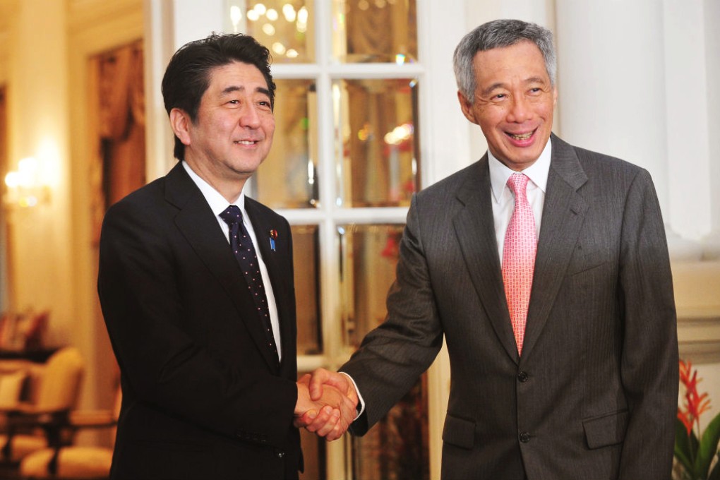 Lee Hsien Loong shakes hands with Japanese Prime Minister Shinzo Abe. Photo: Xinhua