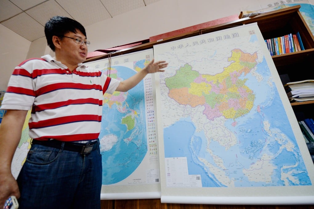 Lei Yixun, editor-in-chief of Hunan Map Press, shows the new vertical map of China. Photo: Xinhua