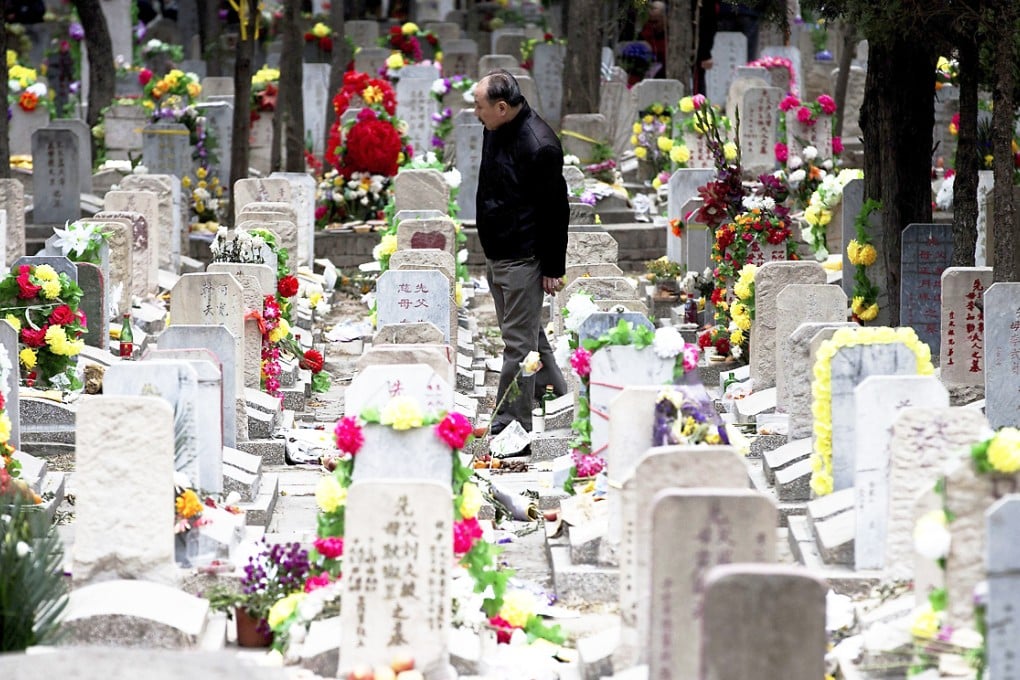 A man looks for his family grave at the Babaoshan cemetery during the Qingming Festival in Beijing. Photo: AP