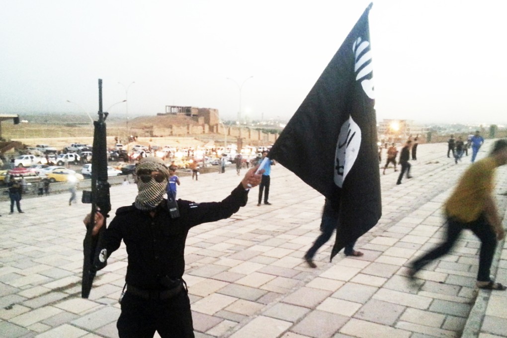 A fighter from the Islamic State of Iraq and the Levant waves the militants' flag in the northern city of Mosul which has been taken over by Islamists. Much of northern and eastern Iraq has now fallen. Photo: Reuters