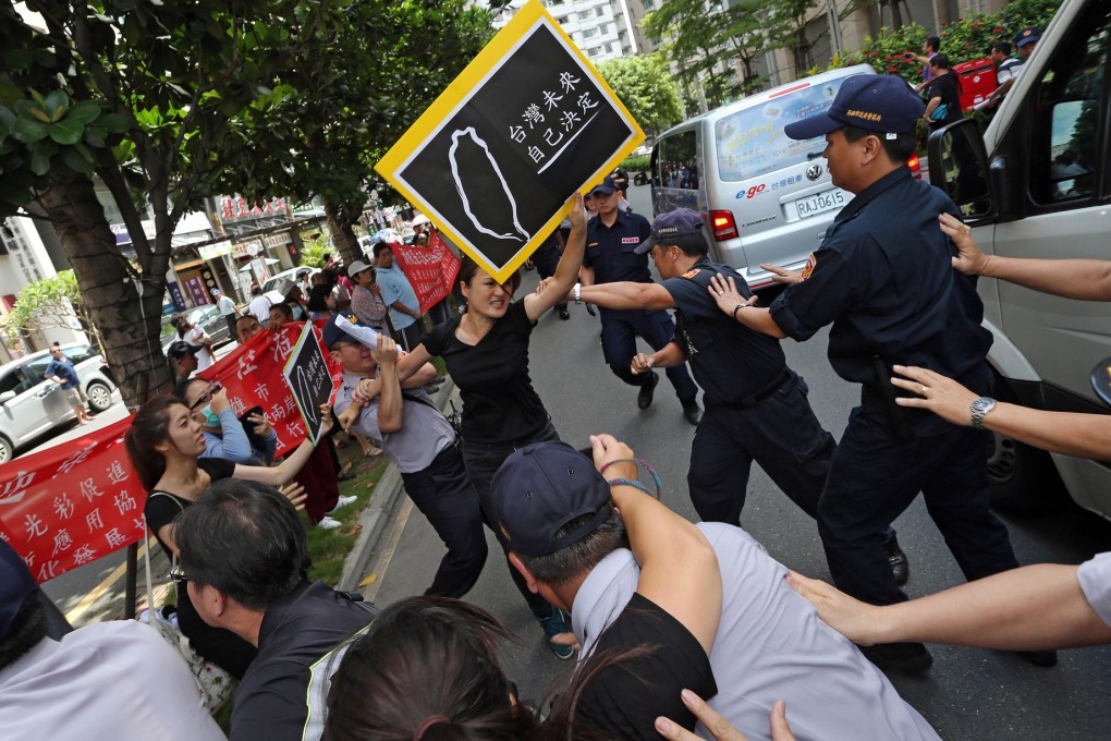 Pro-independence activists scuffle with police in Kaohsiung outside the venue where Zhang Zhijun was meeting the city's mayor. Photo: AFP