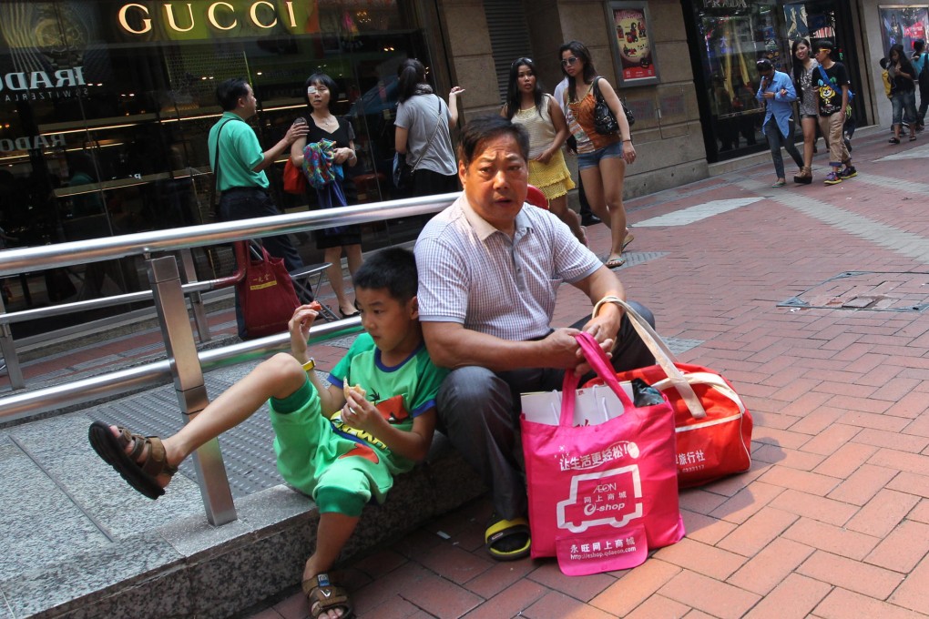 Mainland tourists take a break from shopping in Causeway Bay. While they are a welcome sight for landlords and retailers, many Hongkongers want visitor numbers curbed. Photo: Nora Tam