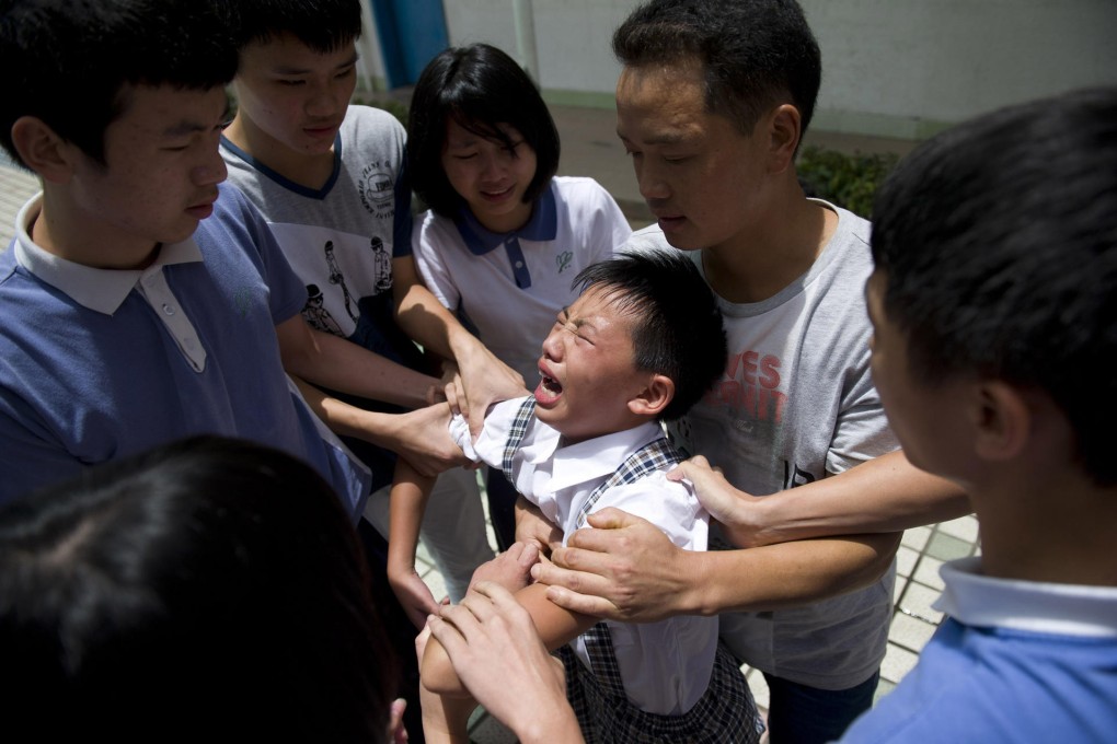 Yang Liujin, 14, cries as Cambridge International Institute students in Shenzhen bid him farewell on Monday. Photo: ChinaFotoPress