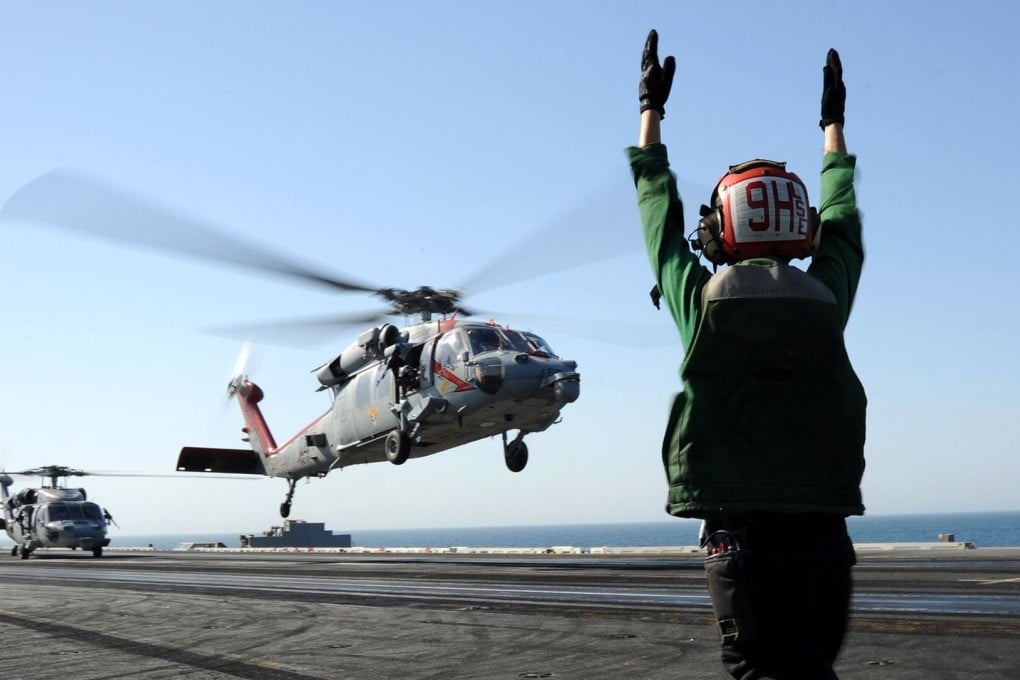 A Seahawk helicopter from the US fleet lands yesterday on an aircraft carrier, based in the Arabian Gulf, that is responding to the crisis in Iraq. Photo: AFP