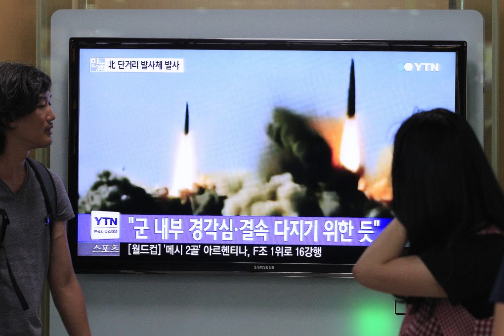 People watch a TV news program in South Korea showing North Korea fired three short-range projectiles Thursday into the waters off its east coast. Photo: AP