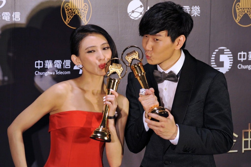 Penny Tai (left) and JJ Lin show off their trophies. Photo: AFP