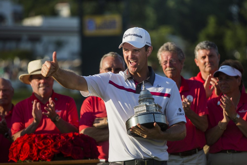 Justin Rose cradles his Quicken Loans National trophy at the Congressional Country Club in Maryland after winning the play-off. Photo: EPA