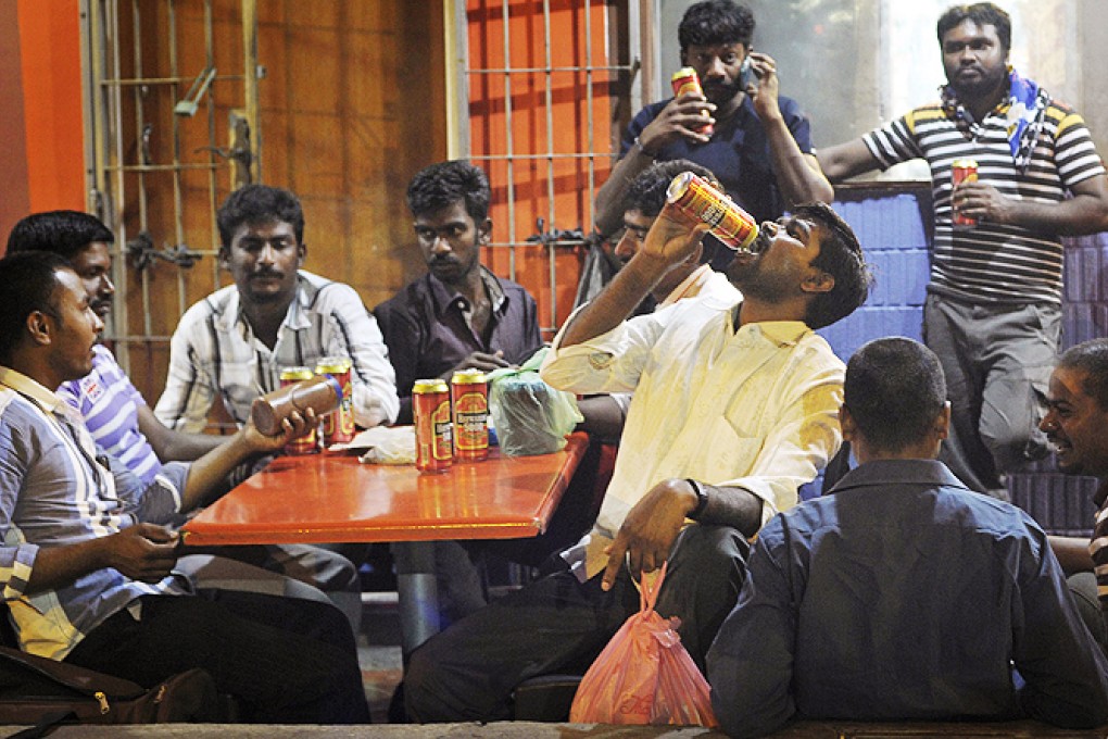 Migrant workers in Singapore enjoying their day off. The city state relies heavily on a large population of temporary, low-paid workers. Photo: AP