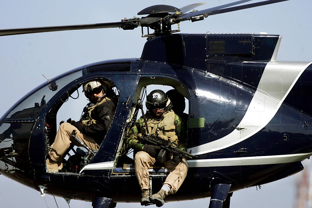 Members of the US-based Blackwater private security firm scan Baghdad from their helicopter. Photo: AFP