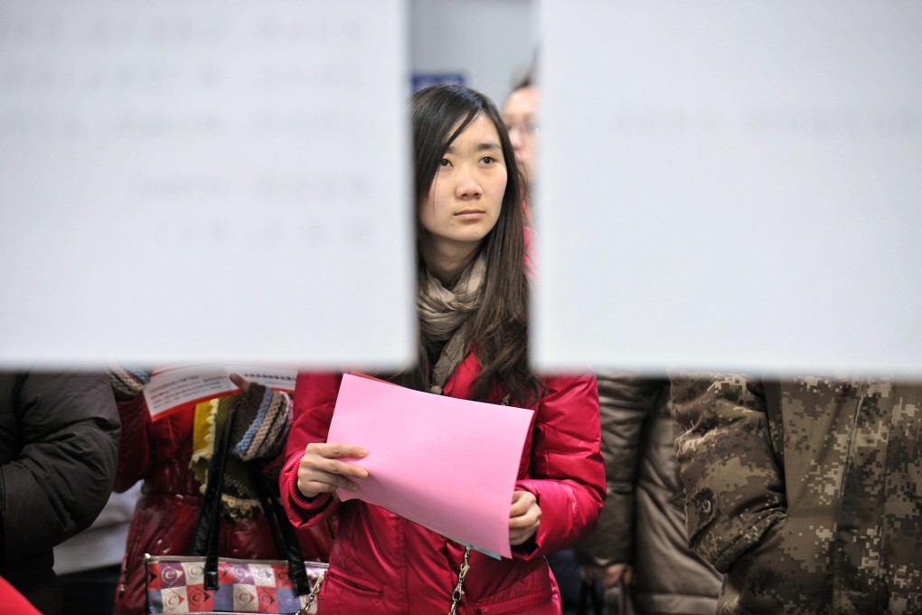 A jobseeker looks at the recruitment information at a job fair for graduates in China. Photo: Xinhua