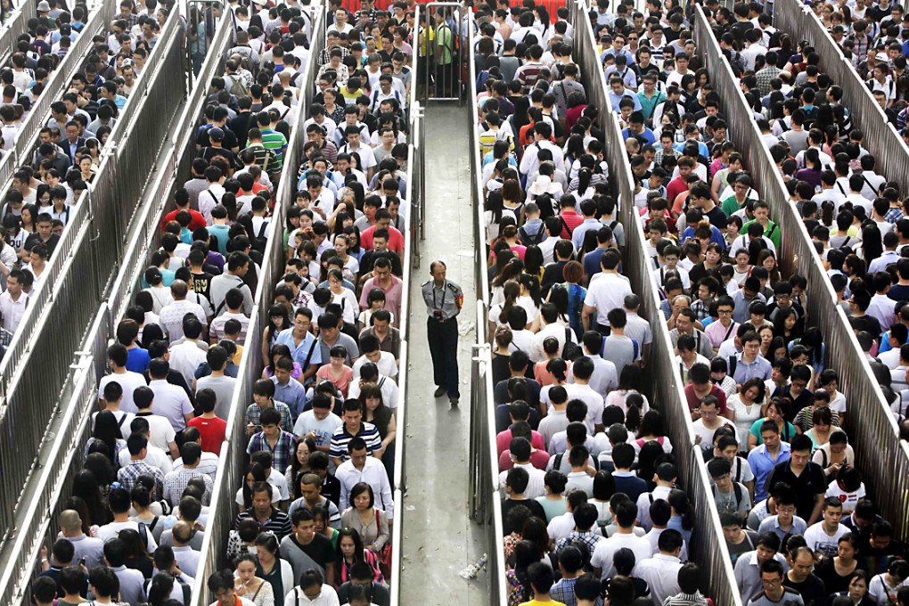 A security officer stands guard as passengers line up and wait for a security check during morning rush hour at Tiantongyuan North Station in Beijing. Photo: Reuters