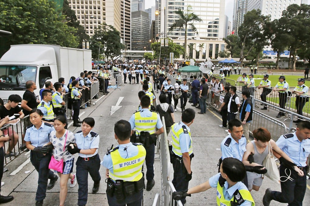 Protesters are taken away by police officers after hundreds of protesters staged a  peaceful sit-ins overnight on a street in Central. Photo: AP