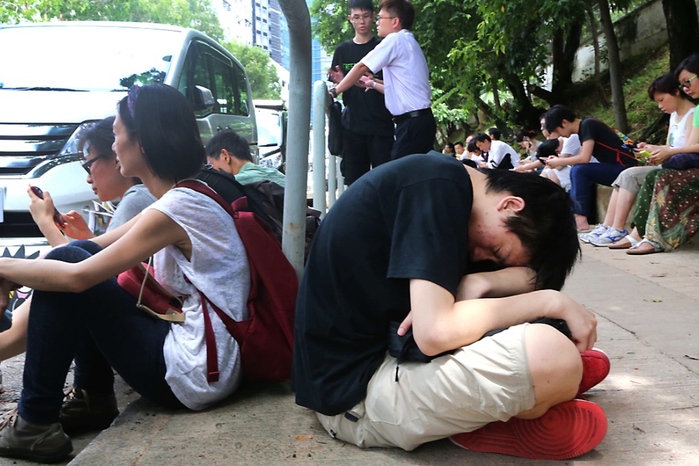 People wait outside the Police College for word on those being held inside. Photo: David Wong