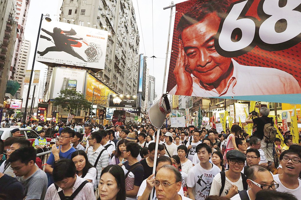 Protesters carry a banner with a portrait of Chief Executive Leung Chun-ying as they join tens of thousands during a march to demand universal suffrage. Photo: Reuters