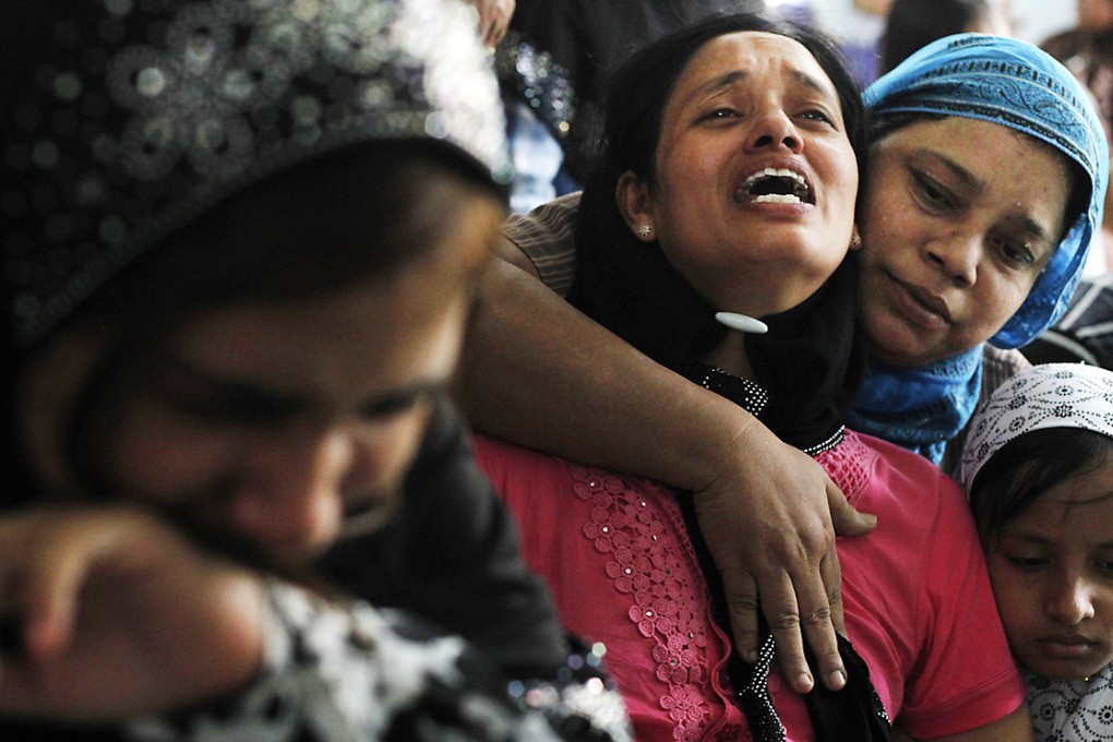 Tin Tin Kyaw (centre) cries near the body of her husband Soe Min, a 51-year-old man who was killed in the riot, at a mosque in Mandalay. Photo: Reuters