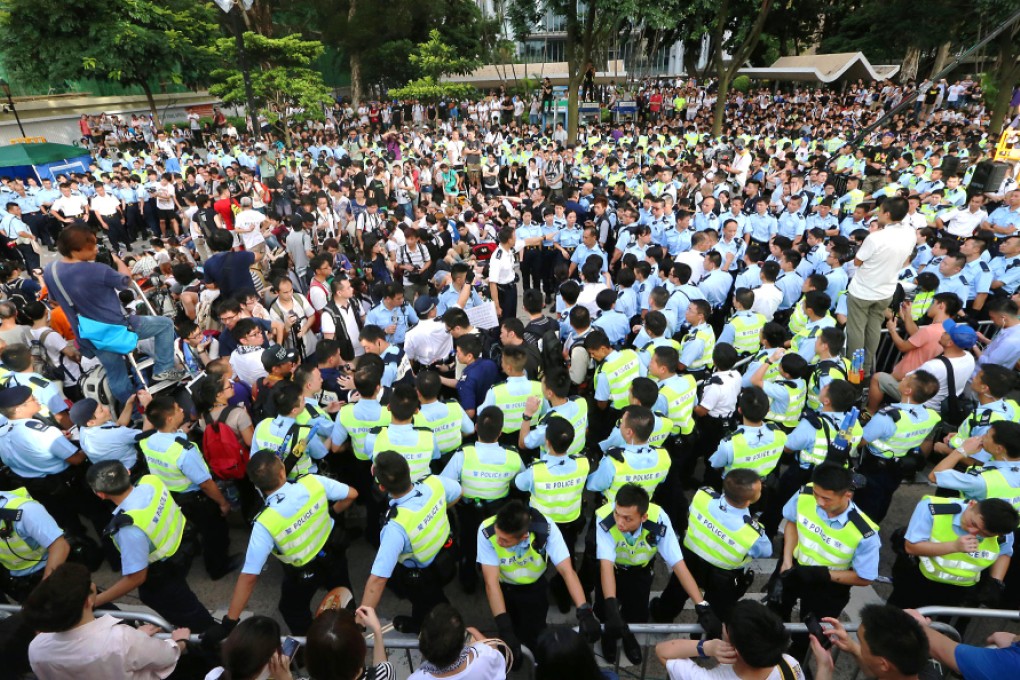Police confront protesters yesterday morning during a sit-in on Chater Road to demand universal suffrage. Photo: David Wong