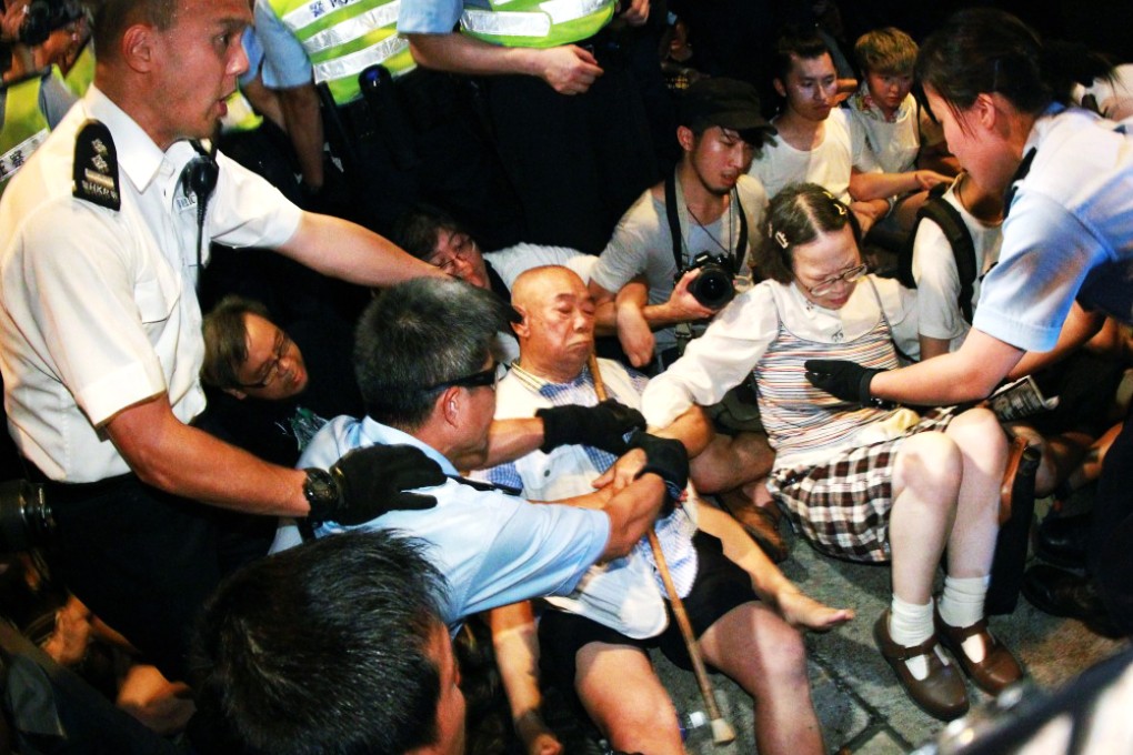 Police attempt to remove two elderly people from Chater Road during Wednesday morning's sit-in. Photo: Dickson Lee