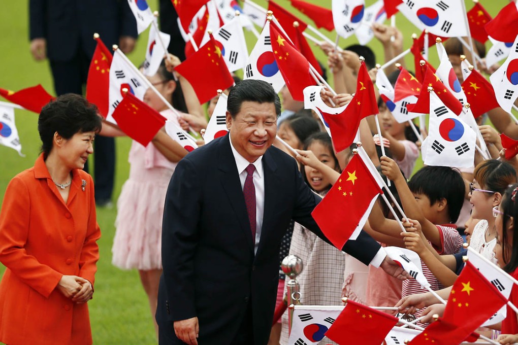 Chinese President Xi Jinping (right) and his South Korean counterpart Park Geun-hye (left) greet children during a welcome ceremony at the Presidential Blue House in Seoul. Photo: AP