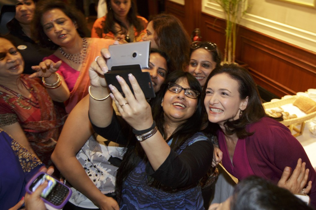 Facebook chief operating officer Sheryl Sandberg pose for a selfie with others at an event in India. Facebook has come under fire for manipulating users' news feeds. Photo: Bloomberg