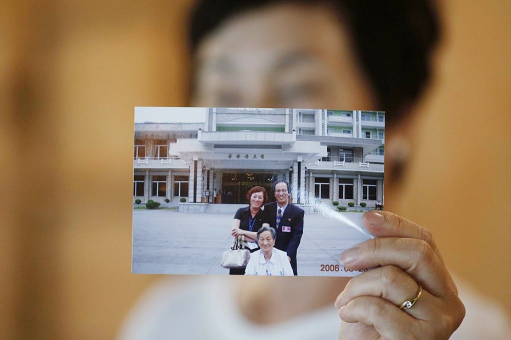 Kim Young-ja holds a photograph of her abducted brother, Kim Young-nam, (right in picture) taken during a reunion in 2006. Photo: Reuters