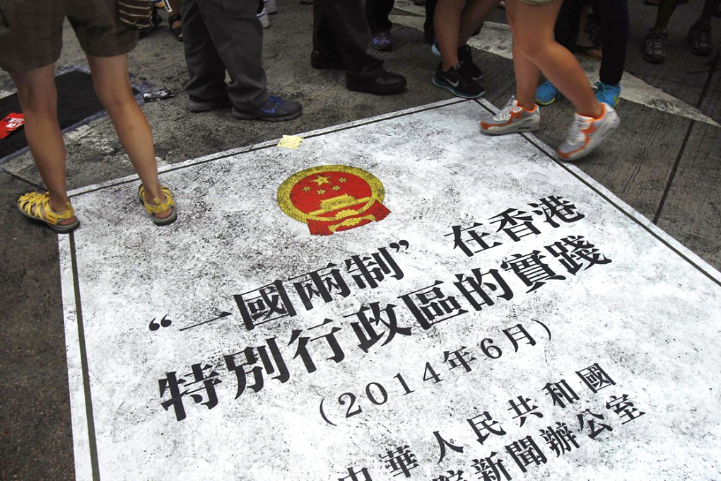 People step on a sign depicting an enlarged cover of China's recent "One country, two systems" white paper over the control of Hong Kong, during a mass protest on July 1. Photo: Reuters