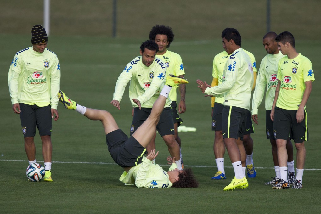 David Luiz stretches, surrounded by his Brazilian teammates during a training session as the hosts prepare for their World Cup semi-final against Germany. Photo: AP