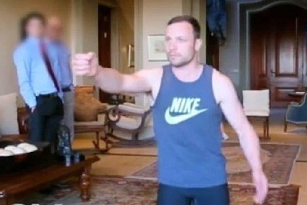 Footage shows Pistorius acting out the night of the killing. He holds his hand in front of him like a gun. Photo: SCMP Pictures