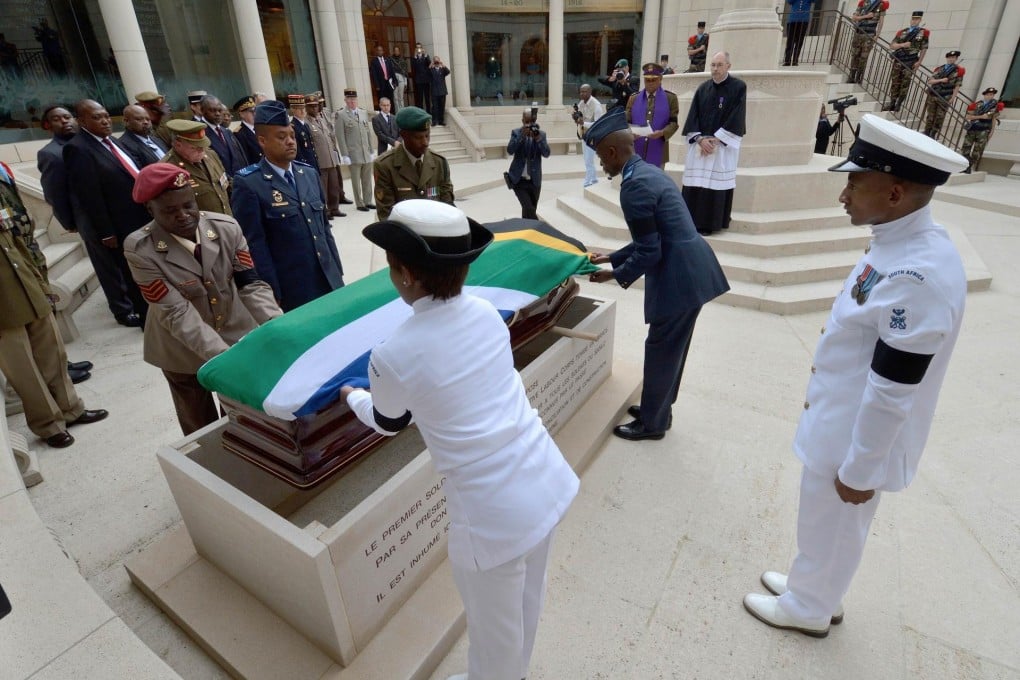 South African officers lay a flag on the soldier's coffin. Photo: AFP