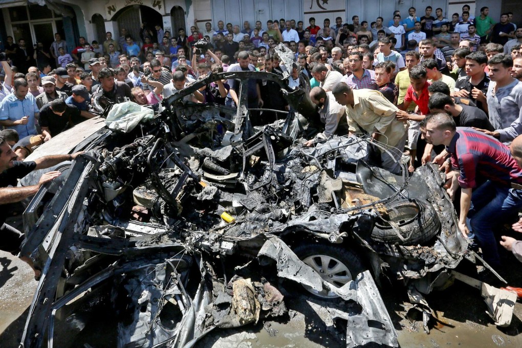 Palestinians examine a wrecked car belonging to militants after an Israeli air strike on Gaza City yesterday as part of an offensive to halt Hamas rocket attacks. Photo: EPA