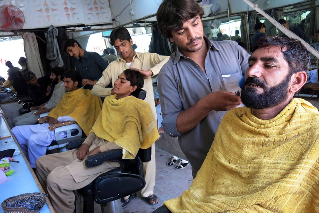 Internally displaced Pakistan civilians fleeing from a military operation against Taliban militants receive haricuts in Bannu. Hundreds of Taliban fighters rushed to disguise themselves with new haircuts. Photo: AFP