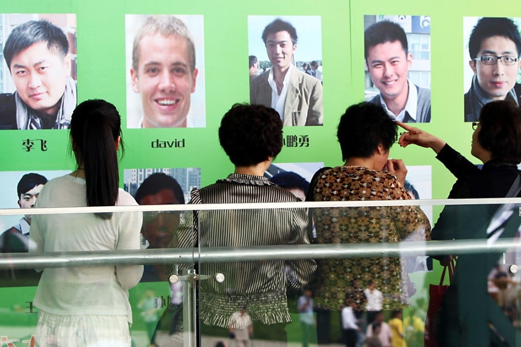 Parents of unmarried young women look at photos of young male singles during a matchmaking event at the Expo Park in Shanghai. Photo: SCMP