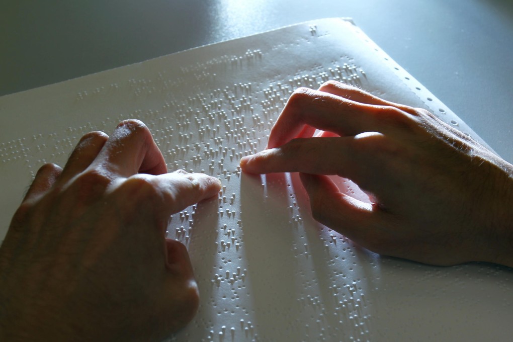 The survey, being read in Braille, said the exam system was hampering visually impaired students' opportunities. Photo: May Tse