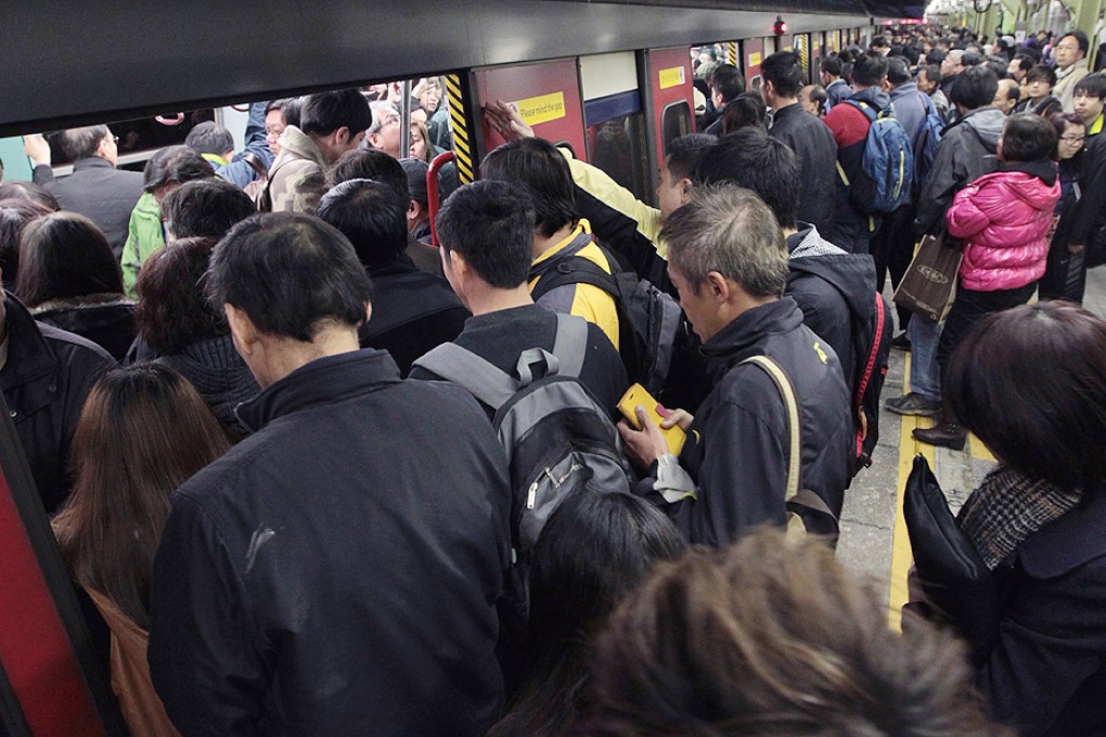 Passengers squeeze into a delayed East Rail train.