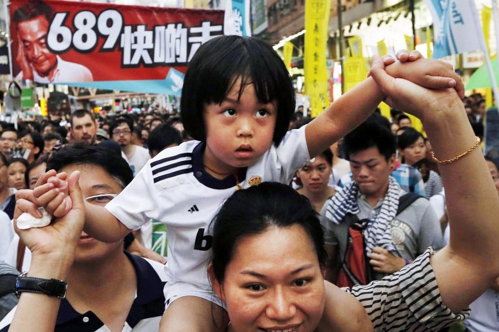 A woman carrying her child on the July 1 march. Photo: Reuters