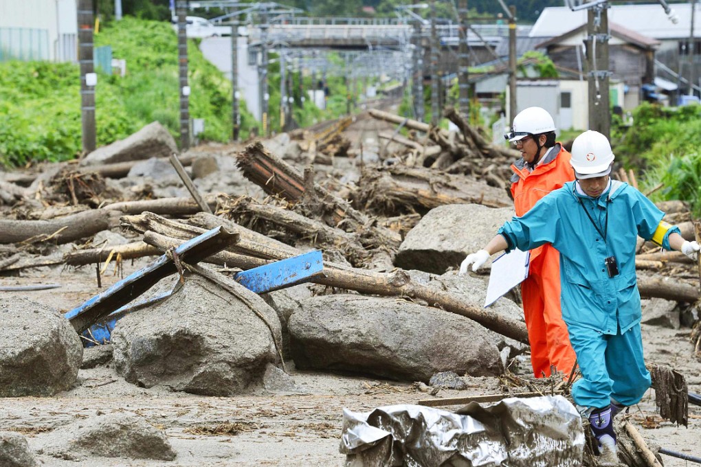 Workers walk among debris at an area affected by landslide caused by heavy rains due to Typhoon Neoguri in Nagiso. Photo: Reuters
