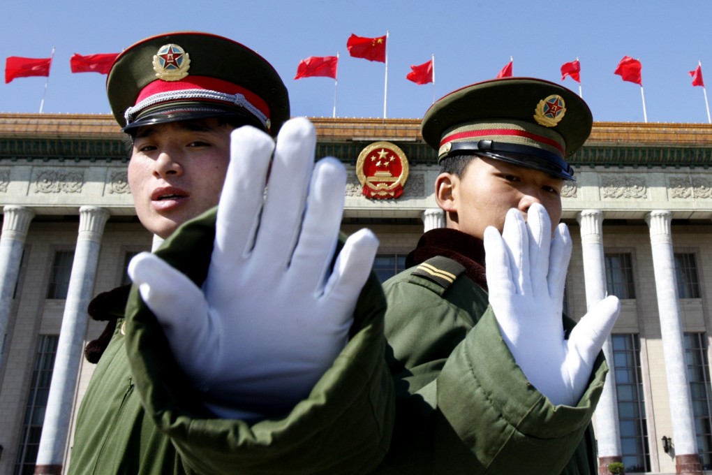 Chinese paramilitary policemen gesture towards a photographer to stop taking pictures as they stand guard at the Great Hall of the People during a key Communist Party meeting. Photo: Reuters